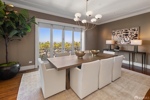 dining room with a notable chandelier, light wood-type flooring, and ornamental molding