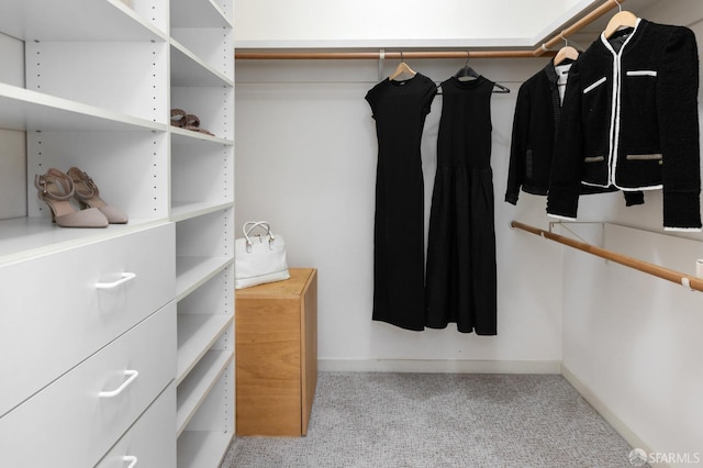 walk in closet featuring light colored carpet