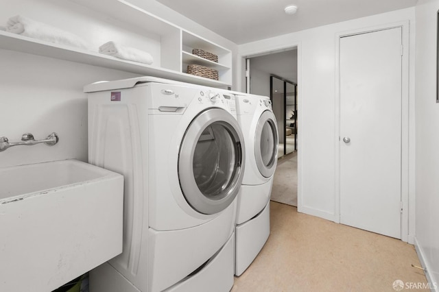 washroom with light colored carpet, separate washer and dryer, and sink