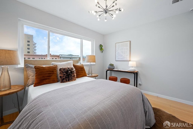 3421 25th St Unit 4, San Francisco, CA 94110 - bedroom featuring wood finished floors, a chandelier, and baseboards