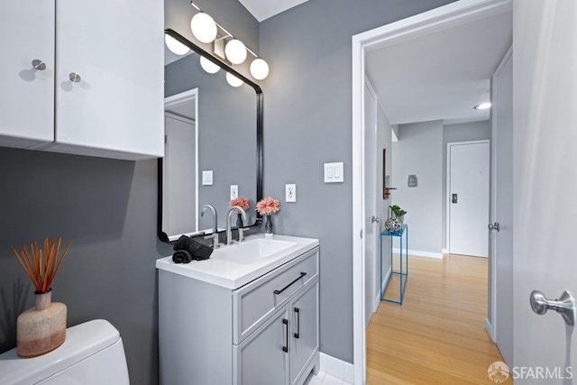 3421 25th St Unit 4, San Francisco, CA 94110 - bathroom with vanity, toilet, wood finished floors, and baseboards