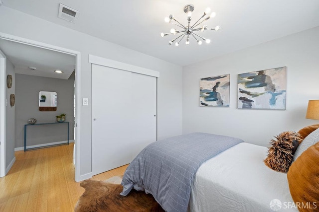 3421 25th St Unit 4, San Francisco, CA 94110 - bedroom featuring a chandelier, light wood-style flooring, a closet, and baseboards