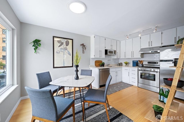 3421 25th St Unit 4, San Francisco, CA 94110 - kitchen with stainless steel appliances, under cabinet range hood, light wood-style floors, light countertops, and a sink