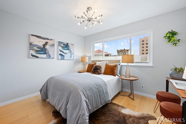 3421 25th St Unit 4, San Francisco, CA 94110 - bedroom with a chandelier, wood finished floors, and baseboards