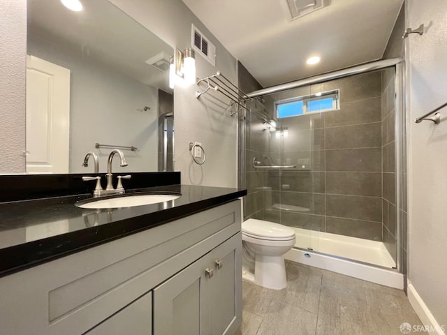 bathroom featuring walk in shower, vanity, and toilet