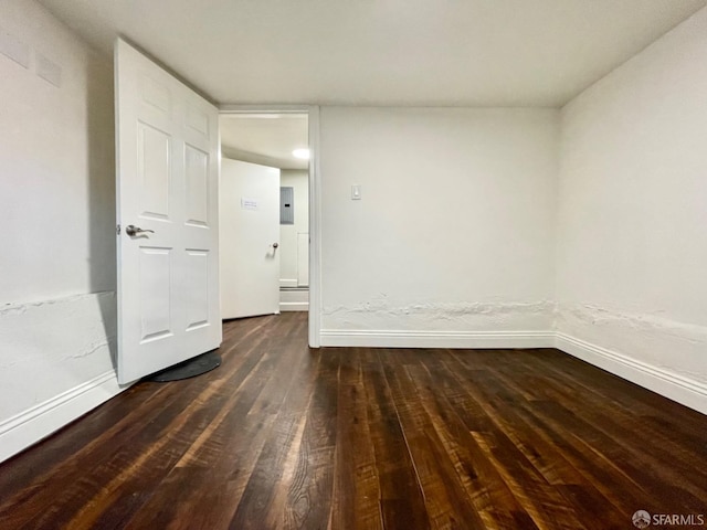 spare room featuring electric panel and dark wood-type flooring