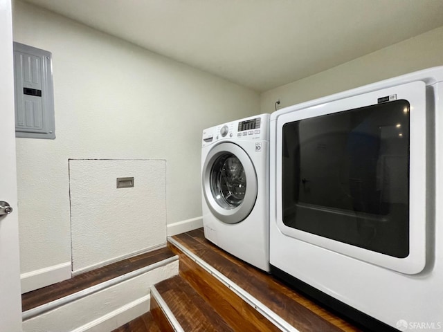 washroom with electric panel, dark wood-type flooring, and washing machine and dryer