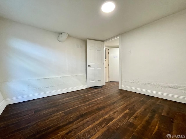 unfurnished room with dark hardwood / wood-style flooring