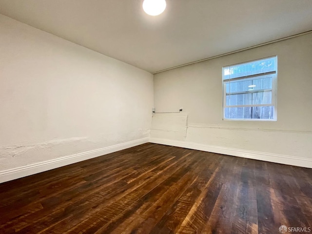 unfurnished room with dark wood-type flooring