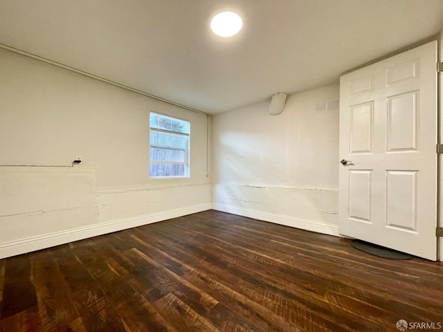 spare room with dark wood-type flooring