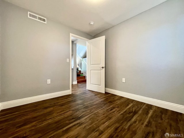 empty room with dark hardwood / wood-style flooring