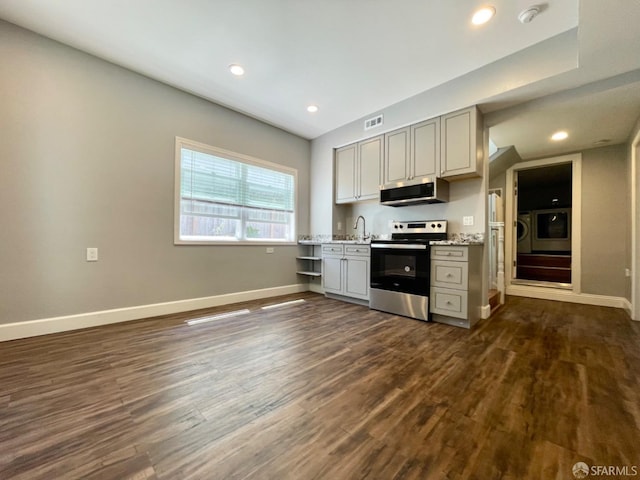 kitchen with light stone counters, washer / clothes dryer, gray cabinets, stainless steel appliances, and dark hardwood / wood-style floors