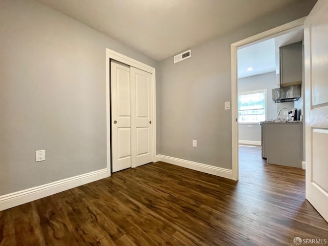 unfurnished bedroom with sink and dark hardwood / wood-style flooring