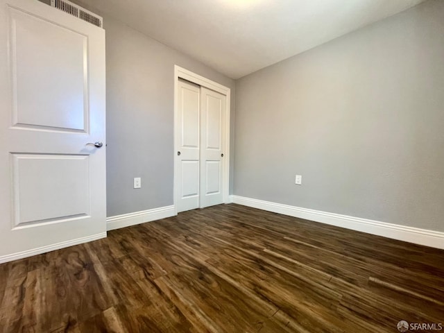 unfurnished bedroom featuring wood-type flooring and a closet