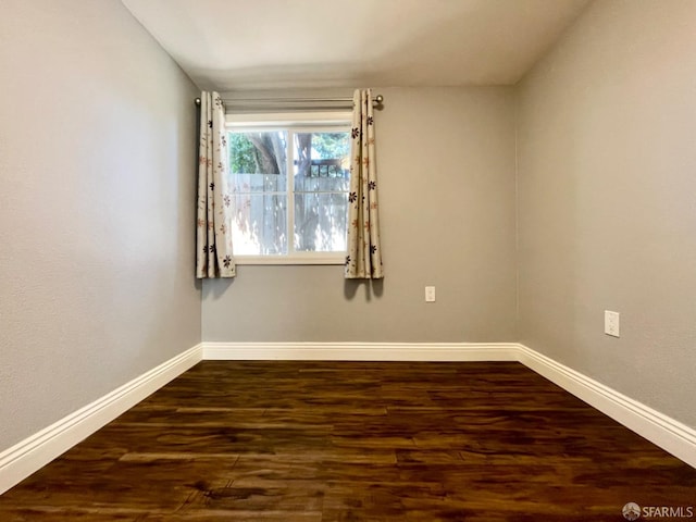 spare room with dark wood-type flooring