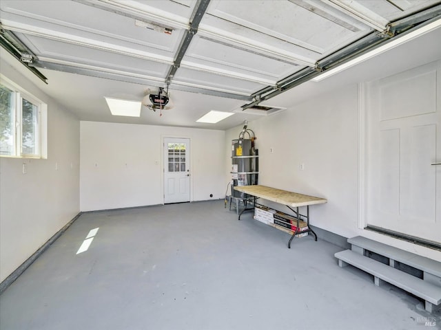 garage with water heater and a garage door opener