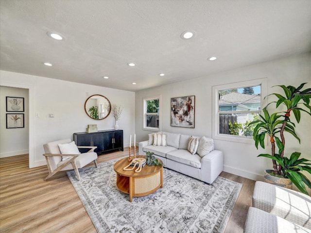 living area featuring recessed lighting, baseboards, and light wood finished floors