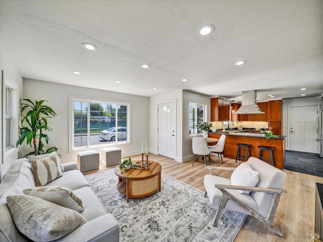 living area with recessed lighting, a textured ceiling, and wood finished floors