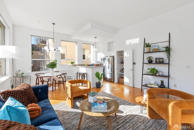 living room featuring a notable chandelier and light wood-type flooring