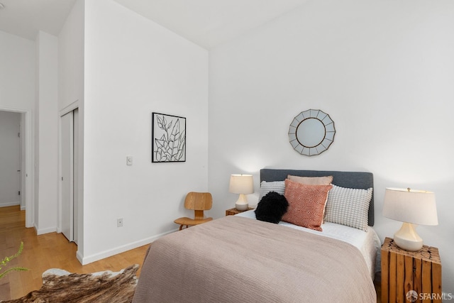 bedroom featuring high vaulted ceiling and light wood-type flooring