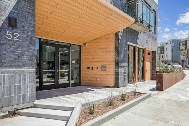 property entrance featuring french doors and brick siding