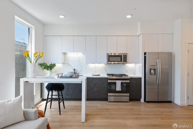 kitchen featuring appliances with stainless steel finishes, white cabinets, and modern cabinets