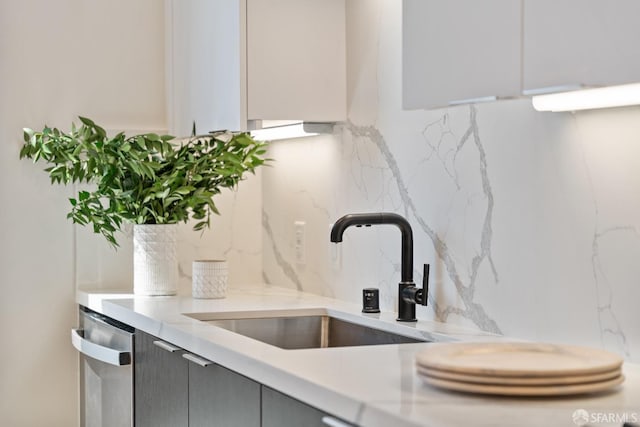 room details featuring gray cabinetry, a sink, backsplash, and dishwasher