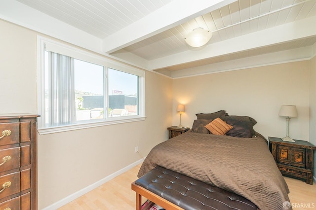 bedroom featuring beamed ceiling and light hardwood / wood-style flooring