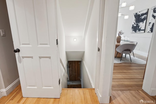 staircase with wood finished floors and baseboards