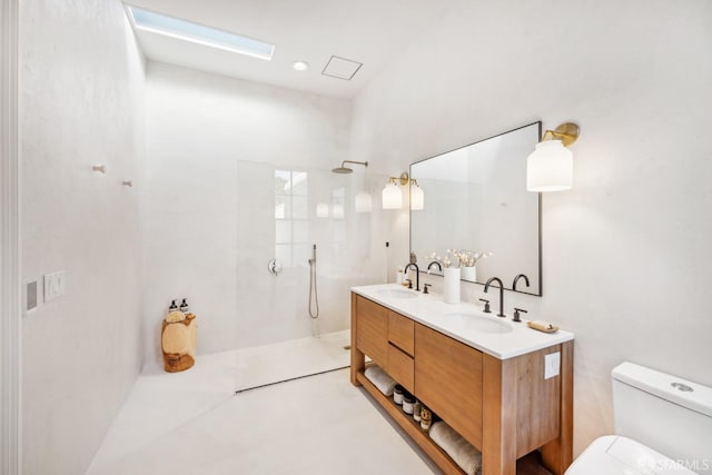 full bathroom featuring toilet, double vanity, a walk in shower, and a sink