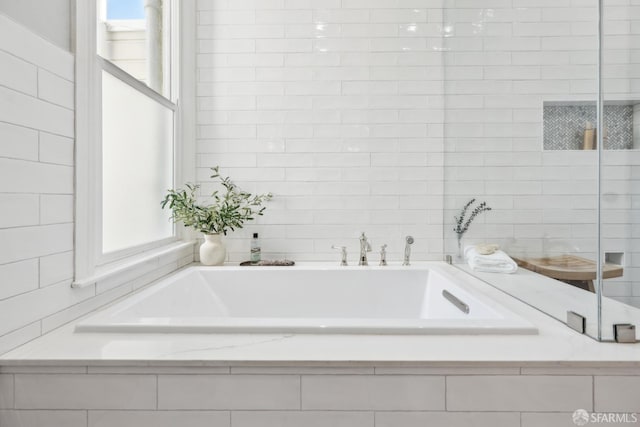 full bathroom with a garden tub, tile walls, and a shower stall