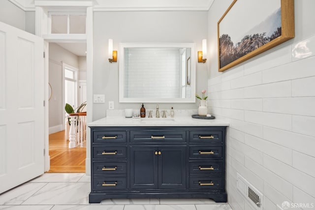 bathroom with marble finish floor, vanity, and visible vents