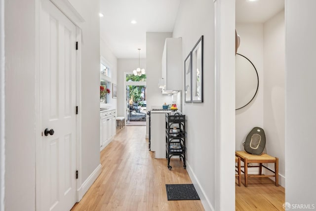 hallway with light wood-style floors, baseboards, visible vents, and recessed lighting