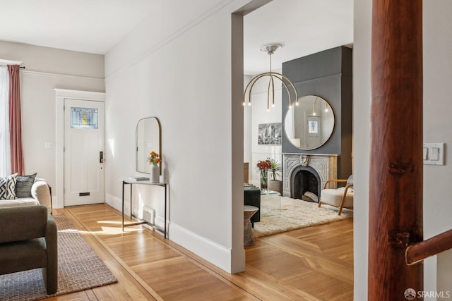 entryway with a fireplace, parquet flooring, and baseboards