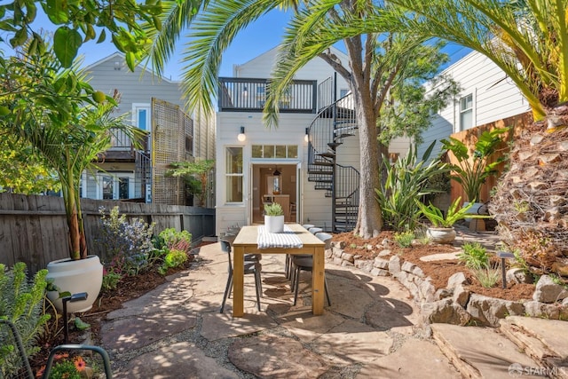 view of patio / terrace featuring stairs, outdoor dining space, and fence