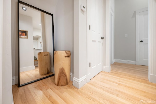 corridor with baseboards and wood finished floors