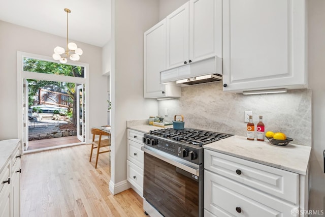 kitchen with extractor fan, range with gas cooktop, backsplash, and white cabinetry