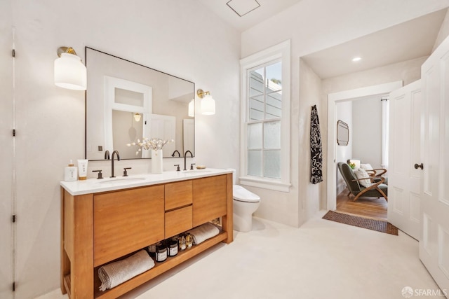 full bathroom featuring double vanity, toilet, and a sink