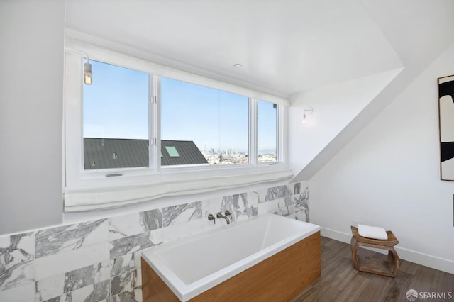 bathroom with wood-type flooring and a tub