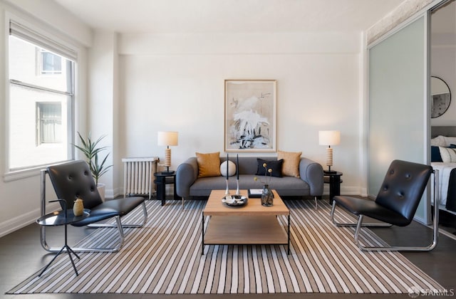 living room with radiator heating unit, wood finished floors, and baseboards