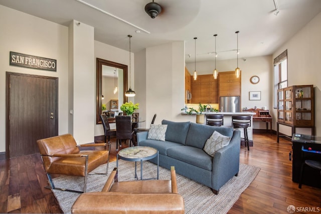 living room with rail lighting and dark wood-style flooring