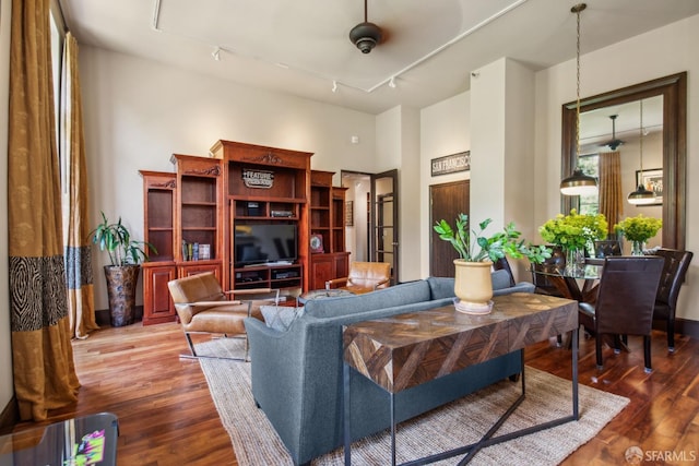 living room with track lighting, wood finished floors, and ceiling fan