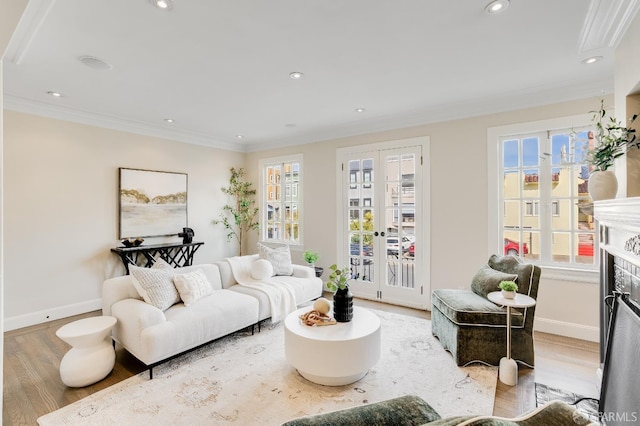 living area featuring french doors, crown molding, and light wood finished floors