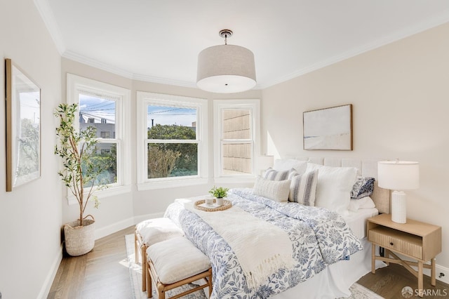 bedroom featuring crown molding, baseboards, and wood finished floors