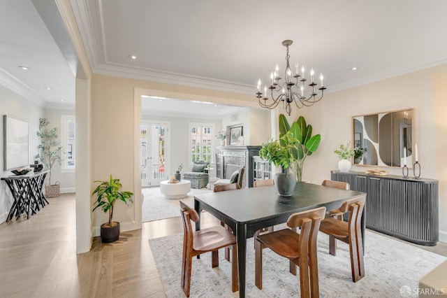 dining space featuring crown molding, baseboards, recessed lighting, light wood-style flooring, and a fireplace