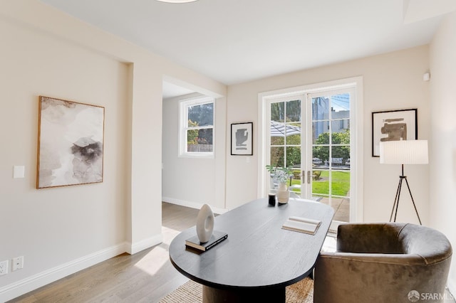 home office with baseboards and wood finished floors