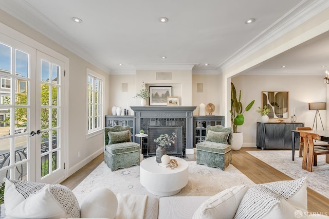 living area with a fireplace, crown molding, recessed lighting, and wood finished floors