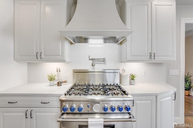 kitchen featuring custom exhaust hood, white cabinets, and light countertops