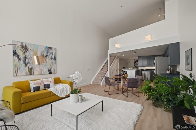 39 Boardman Pl Unit 105, San Francisco, CA 94103 - living area featuring a high ceiling, light wood-style flooring, and stairs