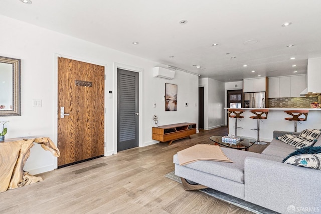 living room featuring light hardwood / wood-style floors and a wall mounted AC